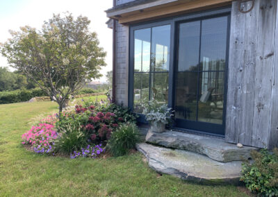 Landscaped exterior with bluestone stairs and salvaged barn door